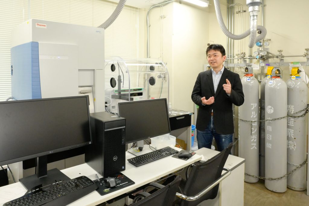 様々なレアメタルを含むサンプルの化学組成分析に用いる誘導結合プラズマ質量分析装置 (左奥の機器)